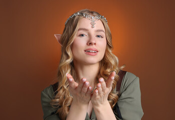 Naklejka premium Beautiful girl dressed as elf on brown gradient background