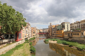 Fototapeta premium The traditional colorful houses of the Onyar River and the Cathedral and Basilica of Sant Feliu in Girona, Catalonia, from the Stone Bridge