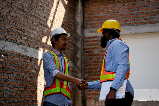 Civil engineer and construction worker manager discussing building site inspection , talking and plan about construction site. Cooperation teamwork. safety gear, project management concept.