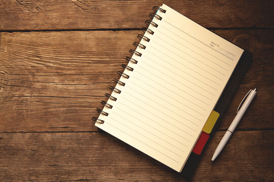 Notebook with pen on wooden table. Top view with copy space