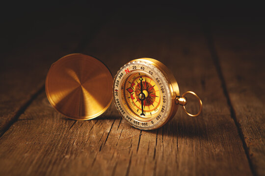 Compass on a wooden background. Vintage style. Selective focus.