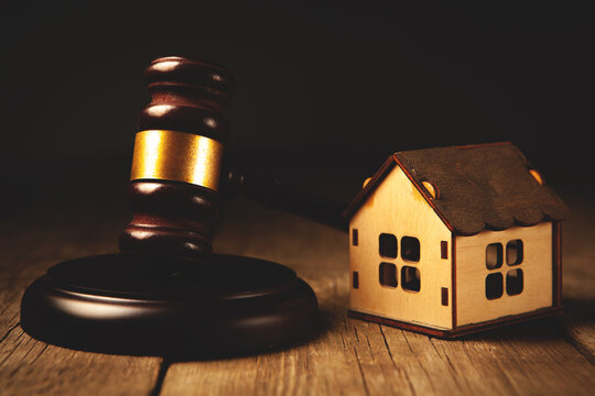 Wooden gavel and house model on wooden table. Law concept