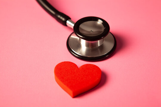 Stethoscope and red heart on a pink background. Health care concept.