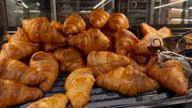 Fresh croissant stack displayed in bakery setting shows pastry texture and golden crust for food marketing visuals. Highlights bakery business, pastry production and breakfast menu promotion.