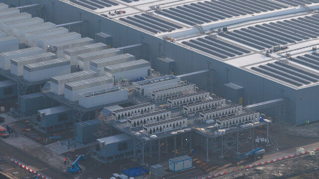 Groningen, Netherlands - 20 January 2026: Aerial view of Datacenter Westpoort featuring extensive cooling systems, rooftop solar panels, and industrial infrastructure under a clear sky.