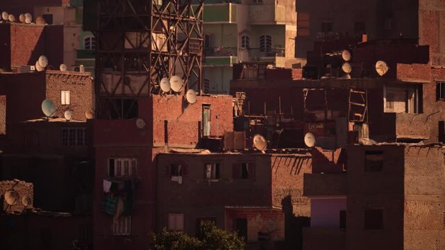 Close-up of Cairo Garbage City buildings stacked with water towers and satellite antennas. Zoom footage showing densely packed residential buildings in Cairo's Garbage City. 