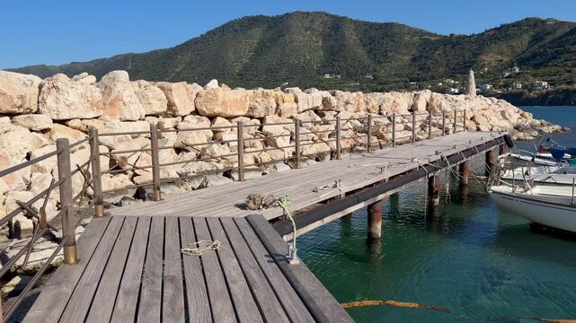 Wooden pier stretching into harbor water shows coastal infrastructure and marine setting for tourism marketing visuals. Supports travel branding, waterfront promotion and seaside destination campaigns