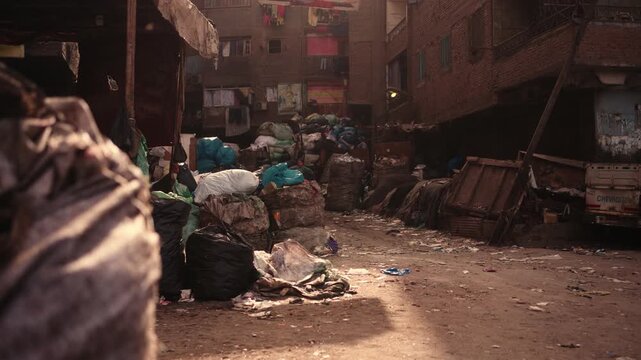 Inner courtyard in Cairo Garbage City with waste bags and dense urban environment. Footage of an inner courtyard in Cairo&rsquo;s Garbage City showing numerous bags of waste