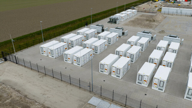 Dronten, Netherlands - 04 April 2026: Aerial view of the Olsterdwarspad battery storage facility with rows of white containers and security fencing.