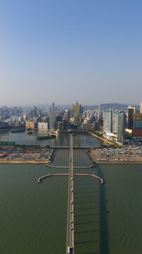 Macao - 18 February 2026: Aerial view of the Grand Lisboa Hotel and the Macau peninsula skyline with the Governor Nobre de Carvalho Bridge stretching across the water.