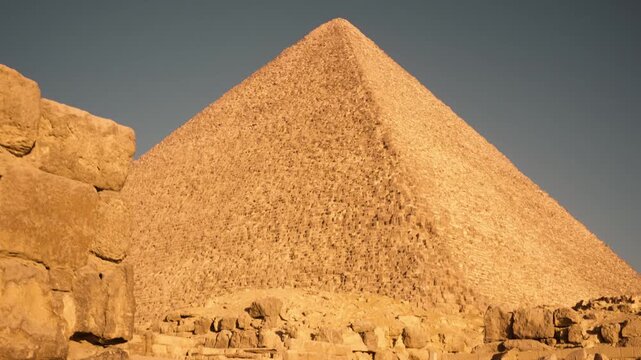 Cinematic morning approach to Great Pyramid of Khufu in Giza Egypt with golden sunlight. A smooth Steadicam shot captures a cinematic approach to the Great Pyramid of Khufu in Giza, Egypt