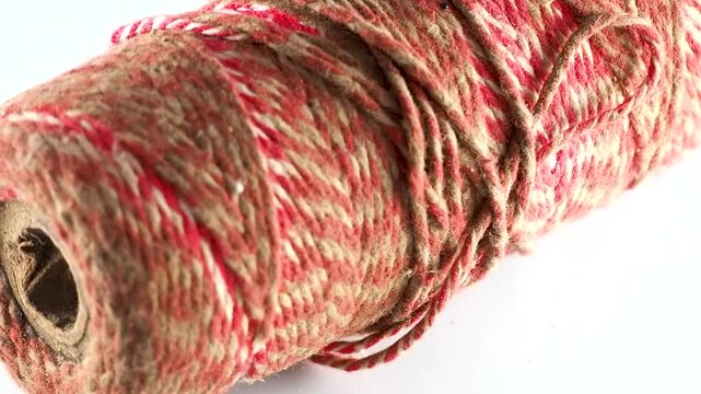 Spinning red and natural jute twine spool