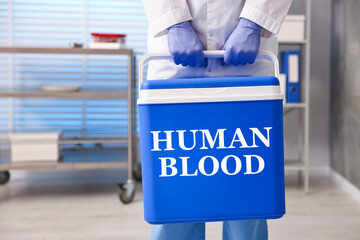 Healthcare worker holding cool box with human blood in hospital, closeup