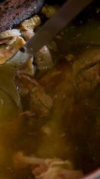 Vietnamese pho bo soup with various herbs, cinnamon, cinnamon stick, star anise, and onion. Cooking pot with bone broth meat pork and beef, aspic north food. spices on kitchen table. 