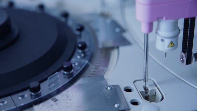 Automated laboratory analyzer dispensing and rotating samples inside clinical diagnostics lab bench.