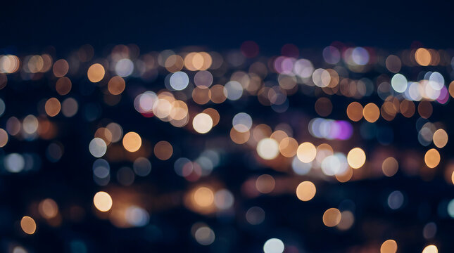 Abstract bokeh city lights at night with blurred background and colorful glowing orbs in dark sky