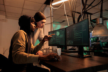 Diverse hackers planning data breach with virus, analyzing firewall encryption to hack computer system. Young team of spies working on breaking database server, steal passwords. © DC Studio