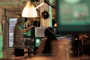 Diverse men working together to break security server, planning data breach with malware and trojan virus. Male hackers doing cyberterrorism attack and stealing passwords, phishing. © DC Studio