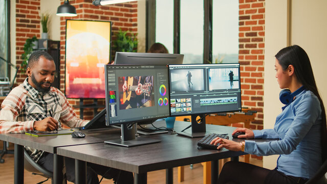 Professional artist working on film footage design with retouching software, using monitors in agency office. Post production house creative editor creating audio and video montage.