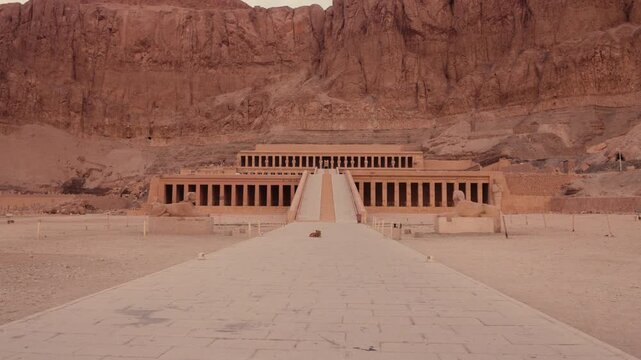Smooth tracking shot of tourists approaching Hatshepsut Temple, Luxor. Cinematic forward movement along the main path leading to the Hatshepsut Temple in Luxor