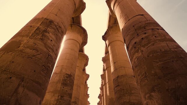 Symmetrical columns walkway Luxor Temple. Smooth cinematic shot along symmetrical pathway lined with columns Luxor Temple. Camera captures balanced composition with open sky visible between columns