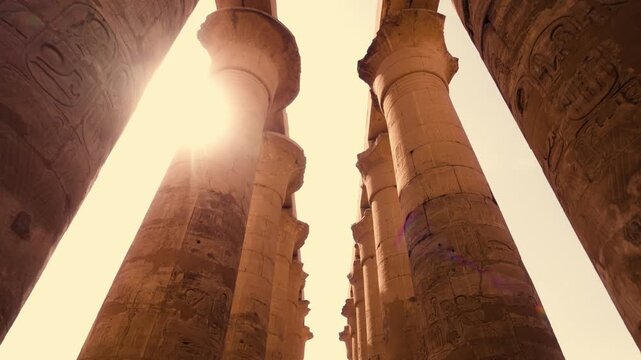 Symmetrical columns walkway Luxor Temple. Smooth cinematic shot along symmetrical pathway lined with columns Luxor Temple. Camera captures balanced composition with open sky visible between columns