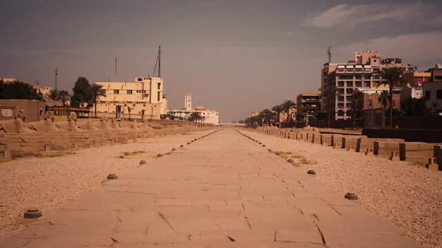 Symmetrical shot of the Avenue of Sphinxes. Luxor. Smooth, symmetrical view of the Avenue of Sphinxes, capturing the alignment of ancient sphinx statues and the grandeur of the historical pathway.