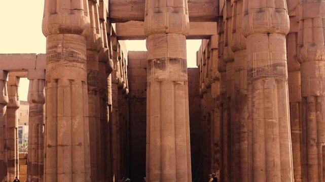 Columns of Luxor Temple side view. Smooth vertical camera movement capturing a side view of a full row of columns in Luxor Temple. 