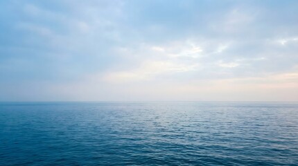 Obraz premium A serene ocean landscape with a vast expanse of deep blue water under a cloudy sky