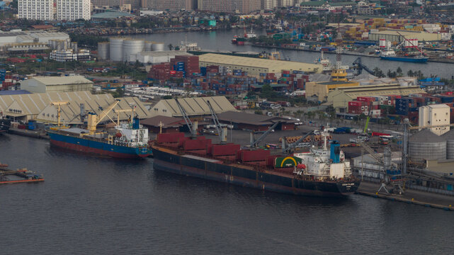 Manila, Philippines - 01 March 2026: Aerial view of Manila Multipurpose Terminal with large cargo ships docked at the pier, shipping containers, and industrial warehouses.