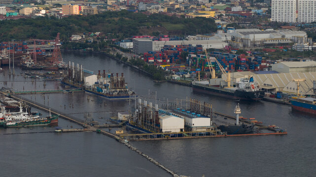 Manila, Philippines - 01 March 2026: Aerial view of Manila Multipurpose Terminal with cargo ships, stacked containers, and industrial barges in the port area.