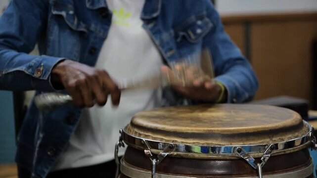 Manos de hombre tocando instrumento tambor de percusi&oacute;n