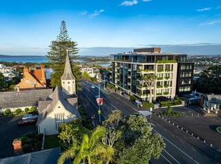 Aerial view of Parnell, Auckland, New Zealand, showcasing a blend of architectural styles. A historic church stands near a modern apartment building, highlighting urban development.  © Stefan