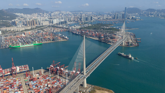 Hong Kong - 15 February 2026: Aerial view of Hong Kong International Terminals and Stonecutters Bridge with rows of shipping containers, gantry cranes, and the urban skyline.