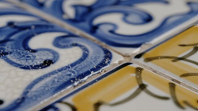 Closeup of antique Portuguese azulejo tiles with blue and yellow patterns.