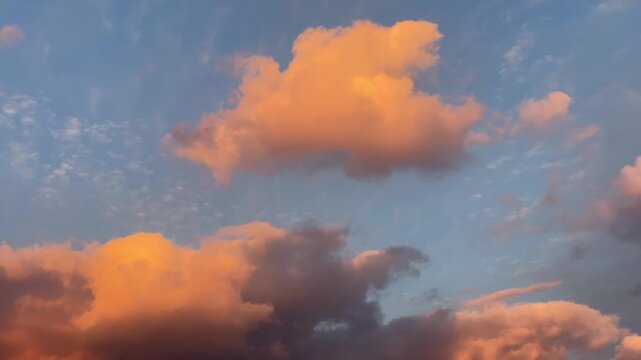 夕暮れの青空にオレンジ色の雲がゆっくりと流れる