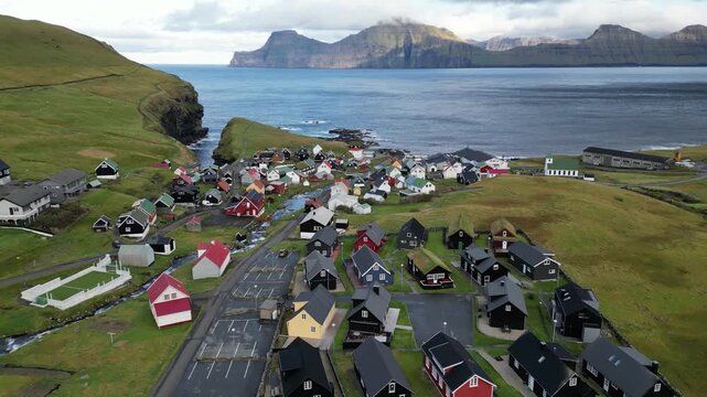 Cinematic 4K aerial drone shot soaring over the coastal town of Gjogv, Faroe islands, Denmark
