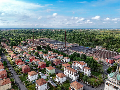 Aerial view of the Industrial Village of Crespi d'Adda with its historic factory chimneys and residential houses surrounded by greenery Capriate San Gervasio, Lombardia, Italy.