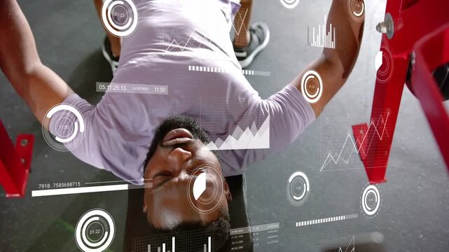 Vertical video: Man bench-pressing after gripping handles, HUD overlaying gauges tracking fitness