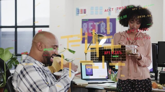 Coworkers sharing jar snack during break as laptop app launching AR HUD showing finance charts