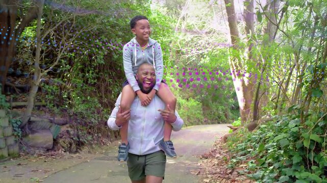 Father lifting child onto shoulders then walking wooded path, animated arrows tracing bond for ads