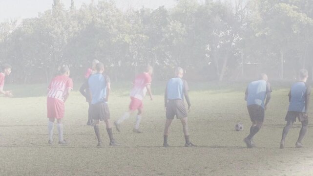 Soccer kicker running, striking ball toward goal trying to score, keeper diving, attackers cheering