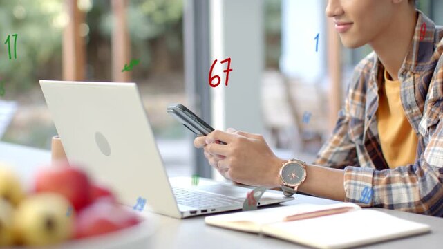 Adult male reading phone then speaking into it for remote work, animated numbers overlaying laptop