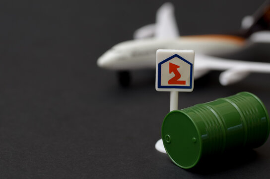 Tourism and Energy Crisis: Miniature Airplane and Oil Drums Illustrating Flight Costs