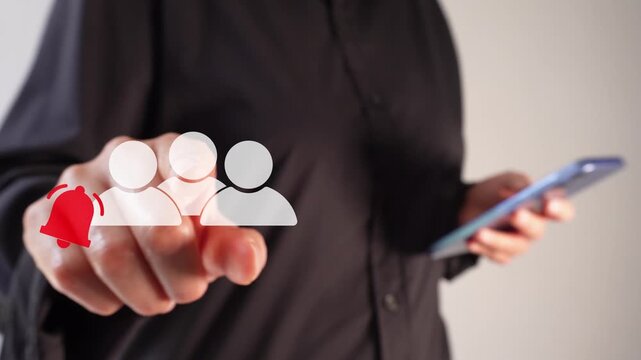 A businesswoman holding a smartphone while pointing forward at an animated group icon with a notification bell. Group notifications.