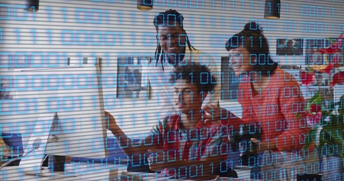 Working three coworkers leaning over monitor in office with binary overlay, wearing red plaid shirt