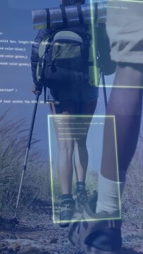 Vertical video: Two hikers hiking dunes, steps causing HUD framing boots, pole, packs for nav tech