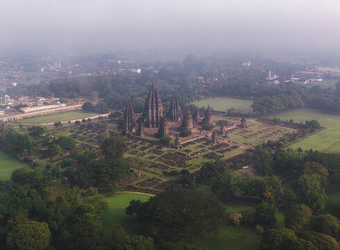 Aerial view of Prambanan Temple, the ancient Hindu temple complex with its towering stone structures surrounded by lush green gardens in Kecamatan Prambanan, Daerah Istimewa Yogya, Indonesia.