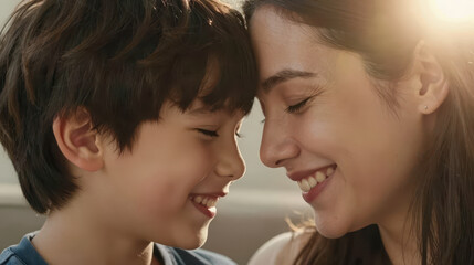 Naklejka premium Mother smiling with child forehead to forehead in warm backlight sharing joyful affectionate moment at home