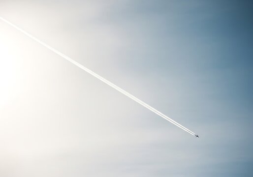 Contrail Jet Flying Across Clear Sky During Daytime.